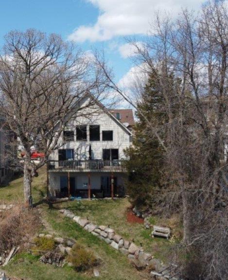 back of property featuring a lawn and a deck