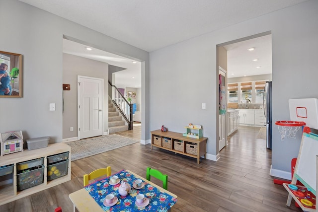 playroom featuring a sink, baseboards, wood finished floors, and recessed lighting