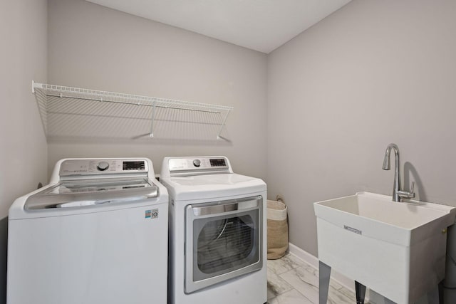 laundry room featuring laundry area, baseboards, marble finish floor, washer and dryer, and a sink