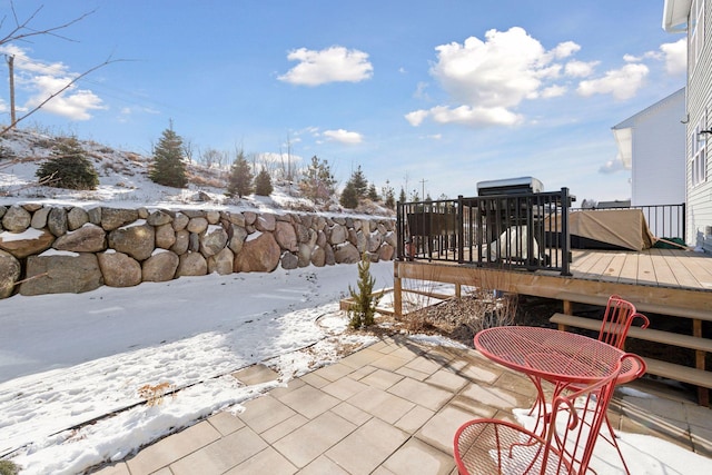 snow covered patio featuring a deck