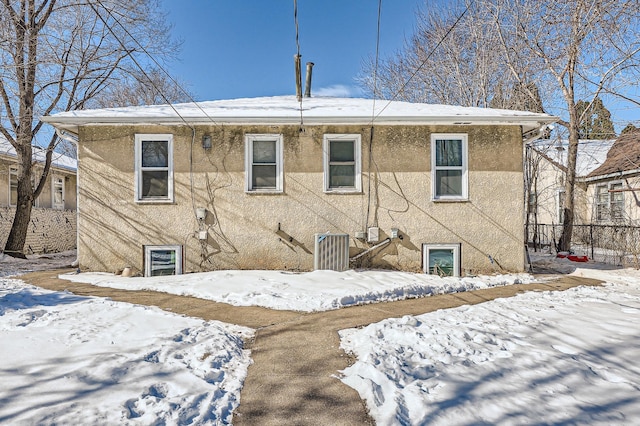 snow covered property with stucco siding