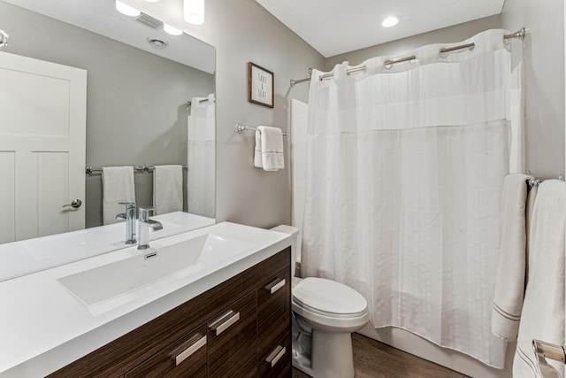 bathroom with visible vents, toilet, shower / tub combo, vanity, and wood finished floors