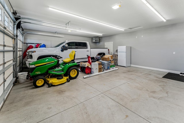 garage with baseboards and freestanding refrigerator