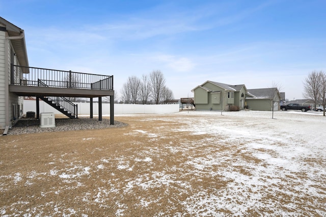 yard covered in snow featuring a wooden deck and stairs