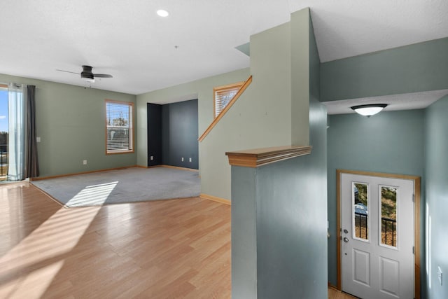 foyer entrance with light wood-type flooring, baseboards, and a ceiling fan