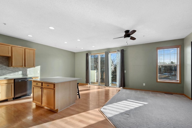 kitchen featuring decorative backsplash, light wood-style floors, dishwasher, and light brown cabinetry