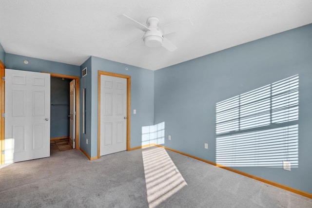 unfurnished bedroom featuring a closet, carpet flooring, visible vents, and baseboards