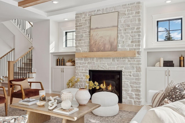 living area with stairway, wood finished floors, a fireplace, recessed lighting, and a high ceiling