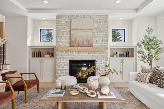 sitting room with light wood-style flooring, healthy amount of natural light, recessed lighting, and a large fireplace