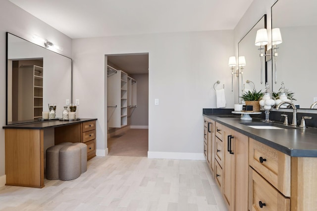 full bath featuring vanity, wood finished floors, and baseboards