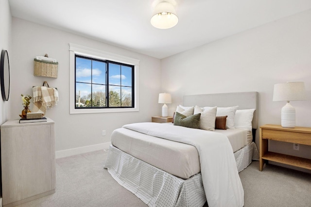 bedroom featuring light carpet and baseboards