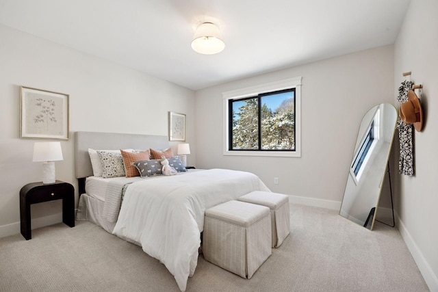 bedroom with multiple windows, light carpet, and baseboards