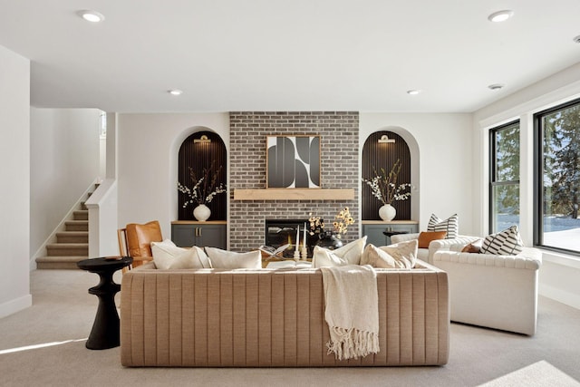 living room with carpet flooring, stairs, a brick fireplace, baseboards, and recessed lighting