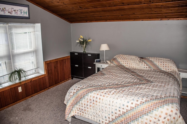 carpeted bedroom with wood ceiling, wooden walls, vaulted ceiling, and wainscoting