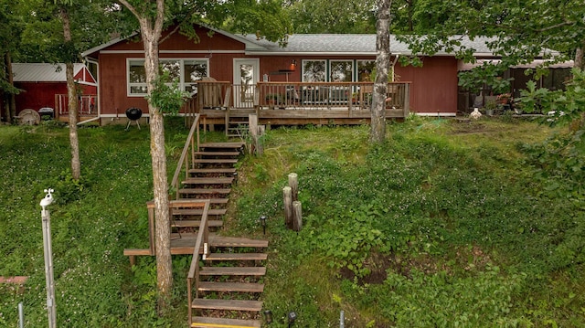 rear view of property featuring a wooden deck and stairs