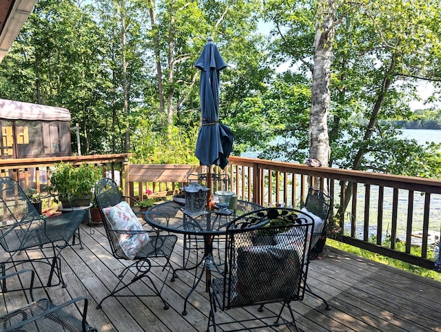 wooden deck featuring outdoor dining area and a water view