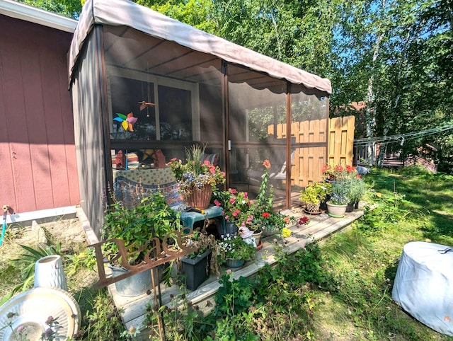 exterior space featuring fence and a sunroom