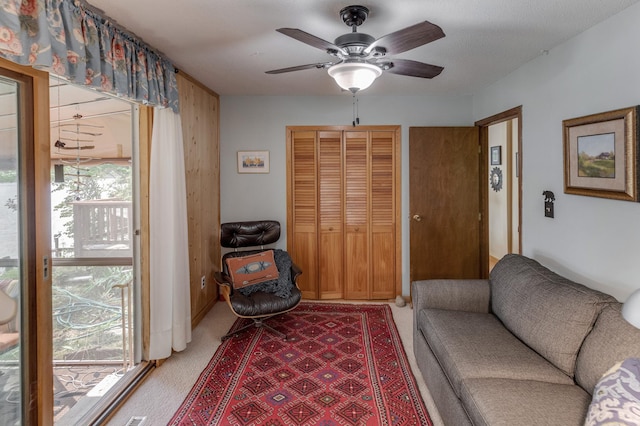 sitting room featuring a ceiling fan and light colored carpet