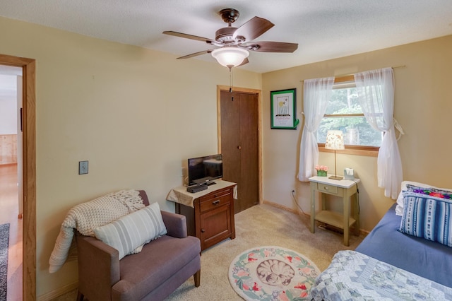 bedroom with light carpet, a textured ceiling, and ceiling fan