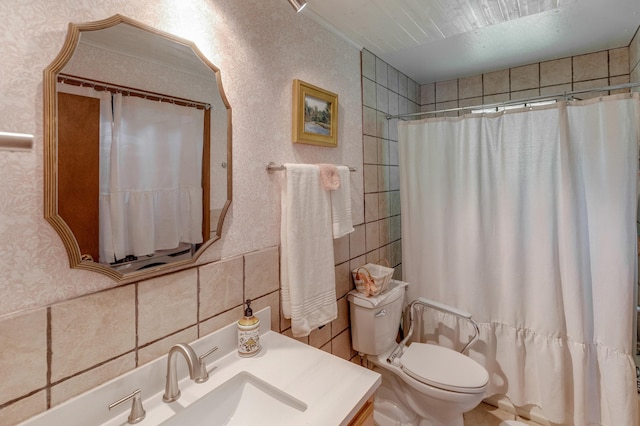 bathroom featuring vanity, a shower with shower curtain, wallpapered walls, tile walls, and toilet