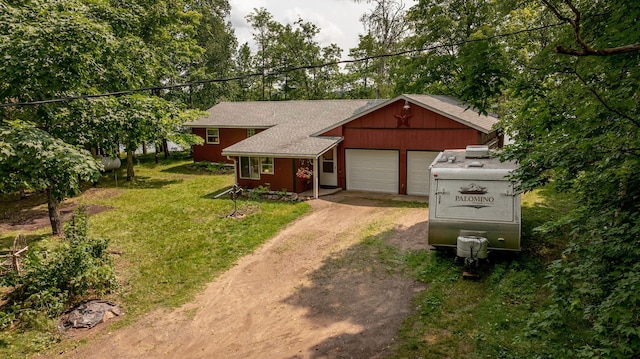 view of front of home featuring a front lawn, an attached garage, roof with shingles, and dirt driveway