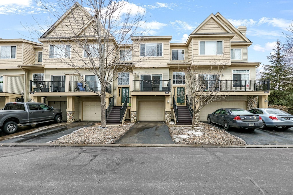 townhome / multi-family property featuring a garage, driveway, and a chimney