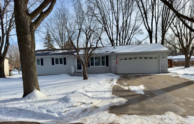 single story home with a garage, stone siding, and driveway