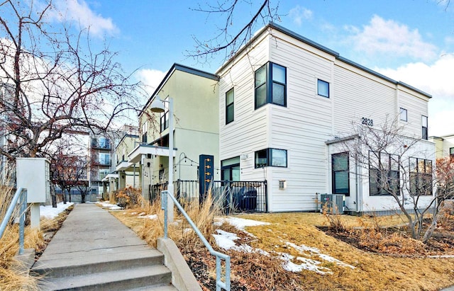 view of home's exterior featuring central air condition unit and fence