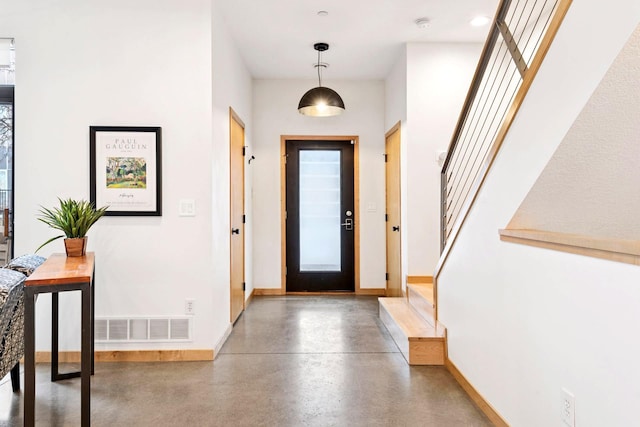 entryway with visible vents, stairway, concrete flooring, and baseboards