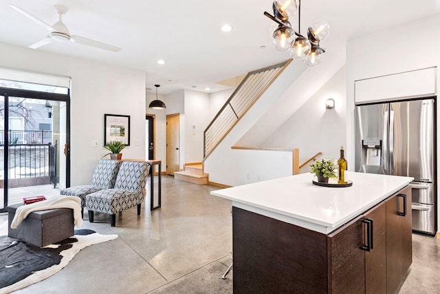 kitchen featuring open floor plan, recessed lighting, concrete flooring, and stainless steel refrigerator with ice dispenser