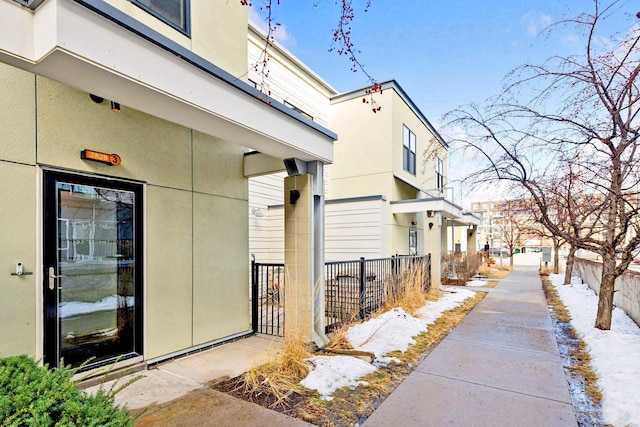 view of home's exterior with fence and stucco siding