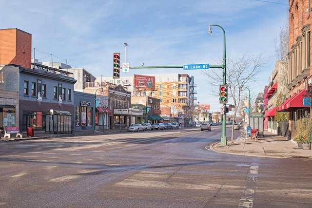 view of road featuring sidewalks, curbs, street lighting, and traffic lights