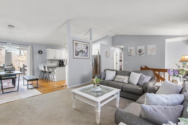 living area featuring lofted ceiling, a chandelier, and light colored carpet