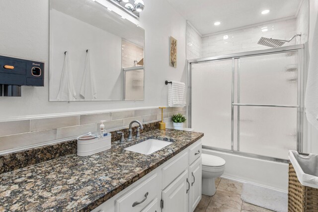 full bathroom with decorative backsplash, toilet, shower / bath combination with glass door, vanity, and recessed lighting