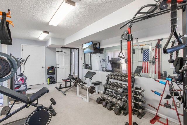 workout area with carpet flooring and a textured ceiling