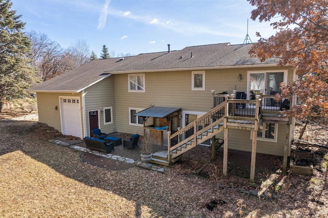 back of property featuring a garage, a shingled roof, a deck, and stairs