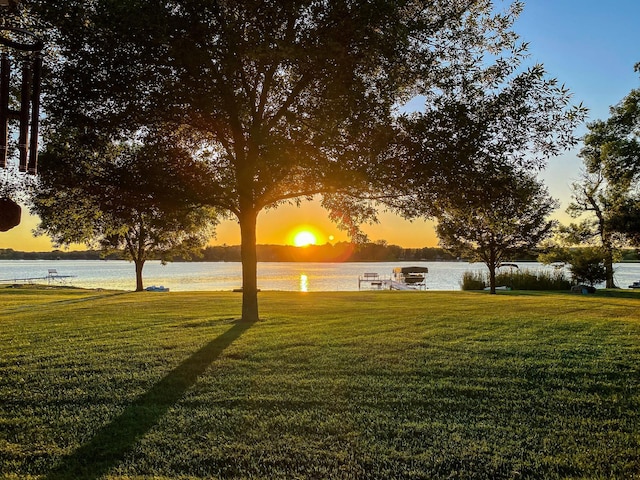 yard at dusk featuring a water view