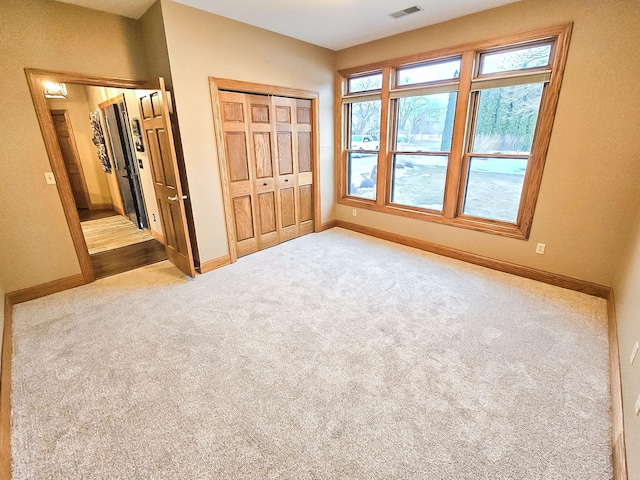 unfurnished bedroom featuring visible vents, a closet, baseboards, and carpet flooring