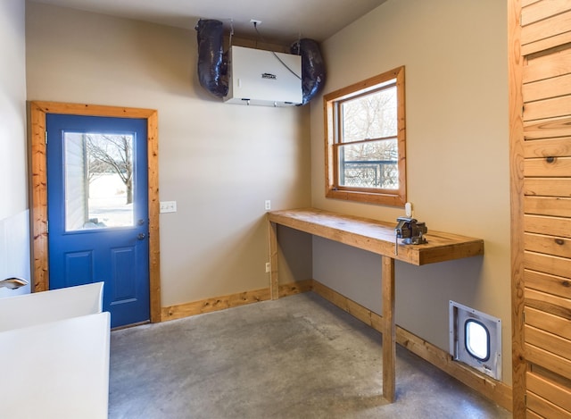 foyer entrance with plenty of natural light, baseboards, and concrete flooring