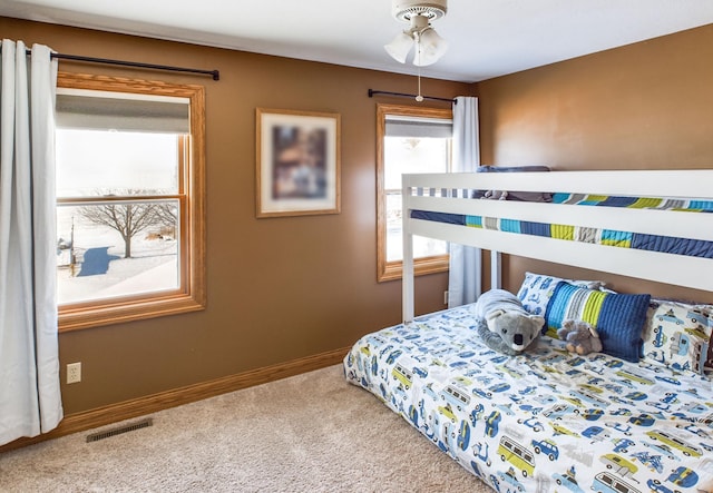 carpeted bedroom featuring baseboards and visible vents