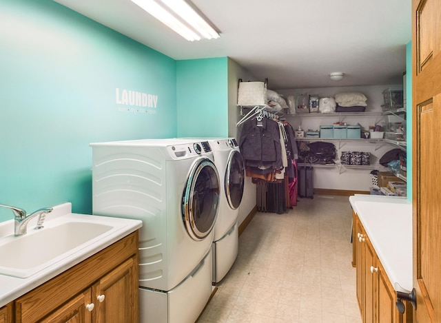 washroom featuring light floors, cabinet space, a sink, and independent washer and dryer