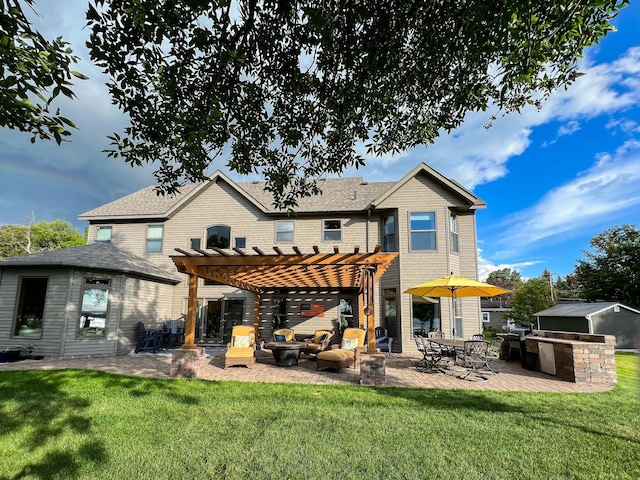 rear view of property featuring a patio area, a lawn, an outdoor kitchen, and a pergola