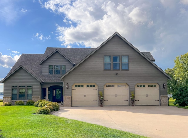 view of front facade with an attached garage, driveway, brick siding, and a front yard