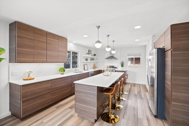 kitchen featuring a sink, a center island, a kitchen bar, stainless steel appliances, and modern cabinets