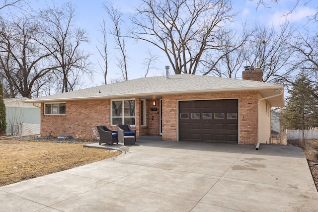 ranch-style house featuring roof with shingles, concrete driveway, an attached garage, brick siding, and a chimney