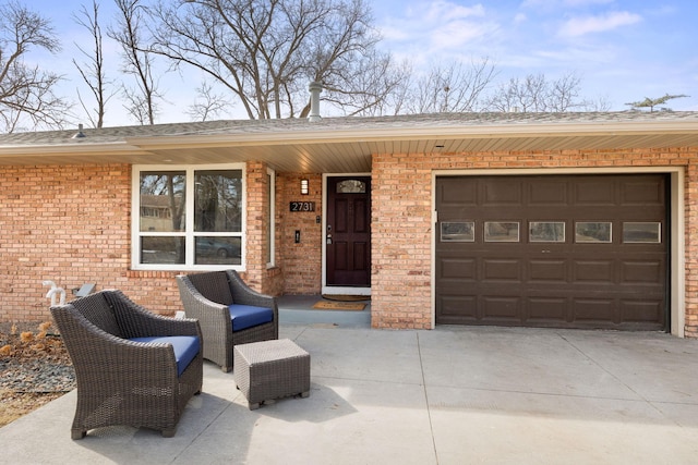 view of front of home with a garage, brick siding, and driveway