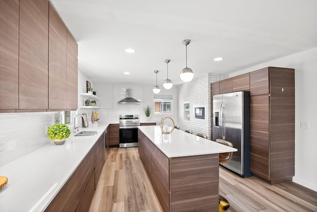 kitchen with modern cabinets, a sink, open shelves, appliances with stainless steel finishes, and wall chimney range hood