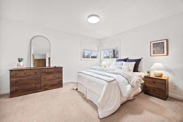 bedroom with baseboards and light carpet