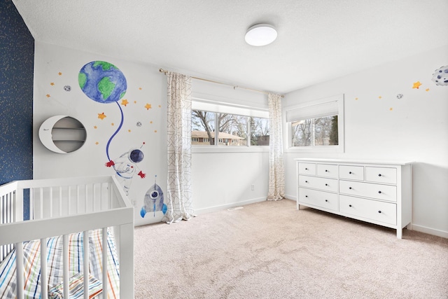 carpeted bedroom with baseboards, a textured ceiling, and wallpapered walls