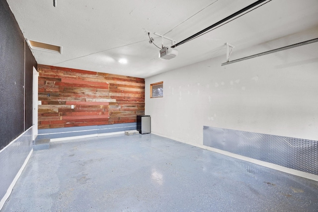 garage with wooden walls and a garage door opener